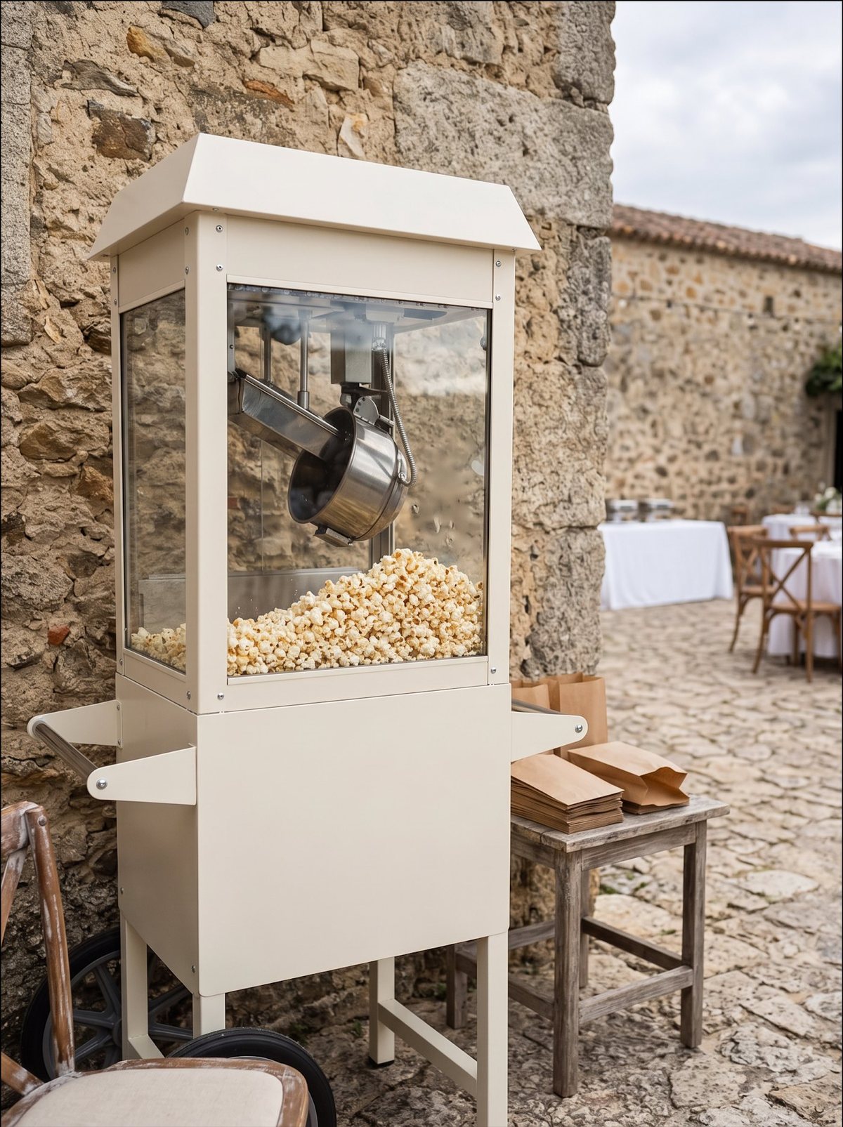Máquina de pipocas vintage em creme numa sala de casamento decorada com flores