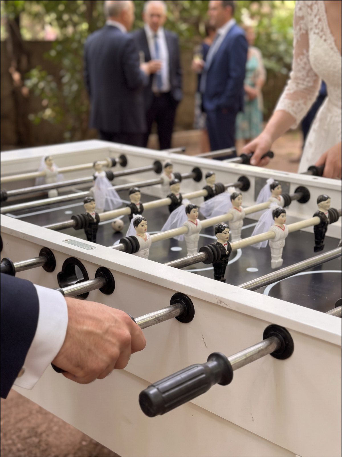 Grande plano dos matraquilhos brancos num casamento, com a noiva ao fundo
