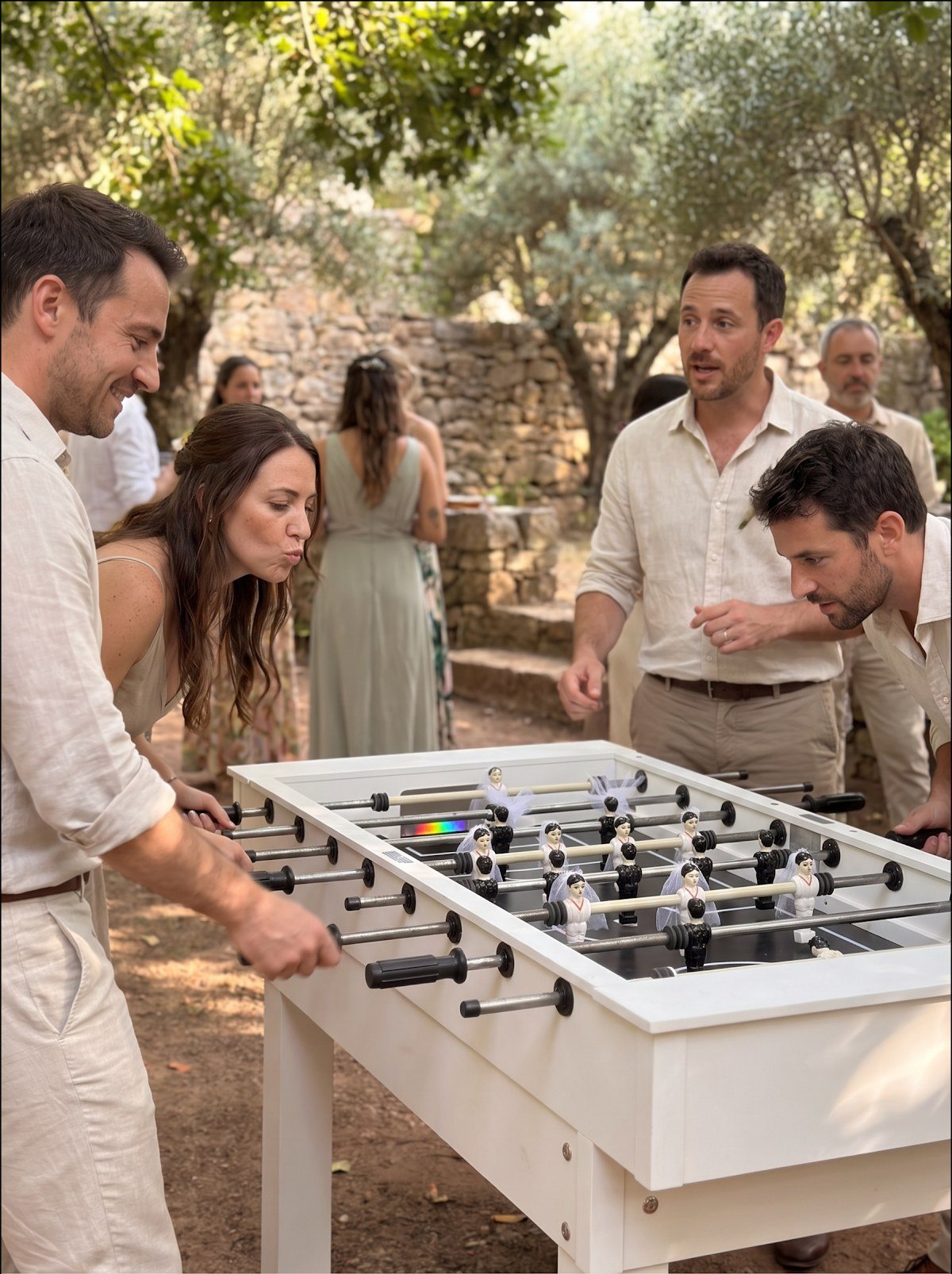 Convidados a jogar matraquilhos brancos num jardim com oliveiras