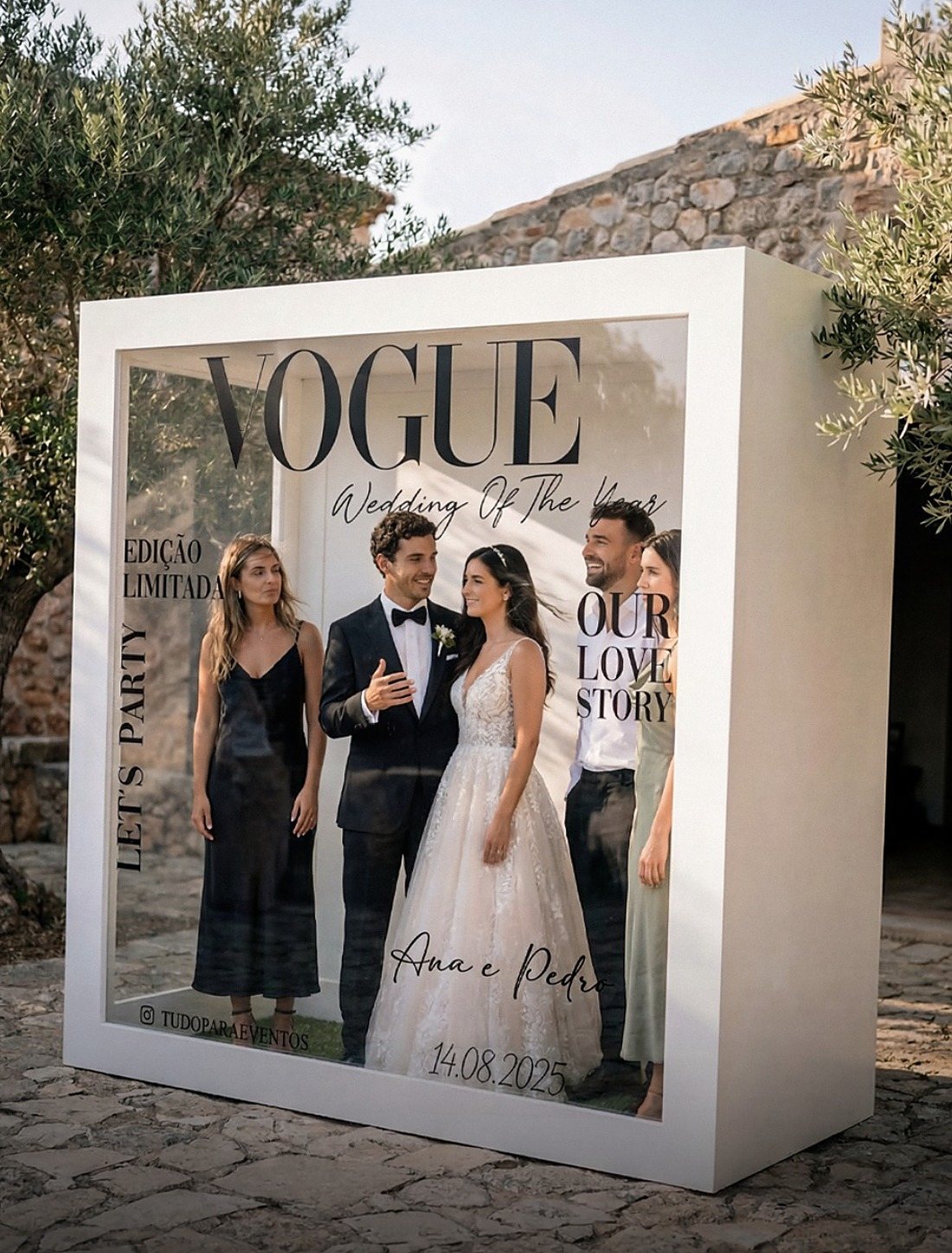 Noivos e amigos dentro do Magazine Booth branco, como capa de revista, num pátio com oliveiras