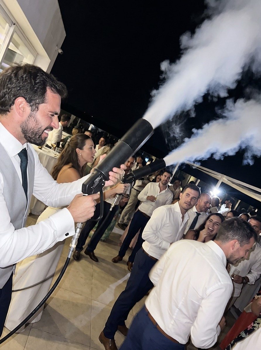 Convidado a disparar jatos de CO2 na pista, à noite, rodeado de convidados